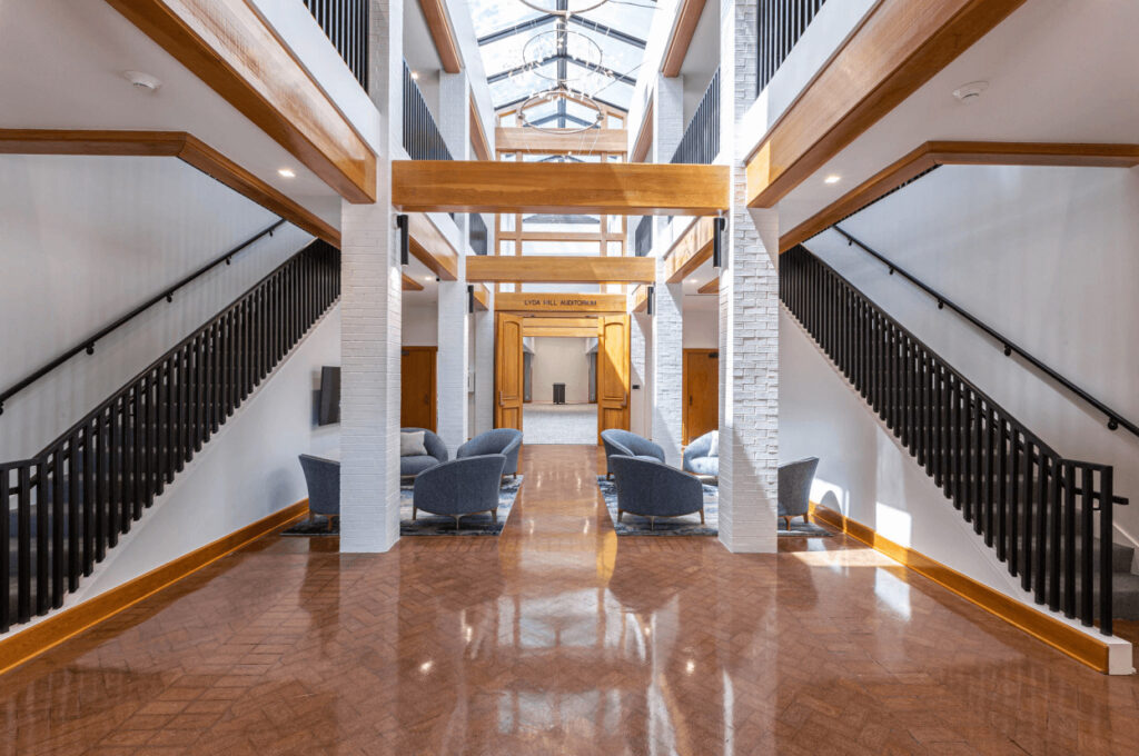 Spacious modern atrium with high ceilings, skylights, and black railings leads to the Junior Leagues Dallas volunteer organization.