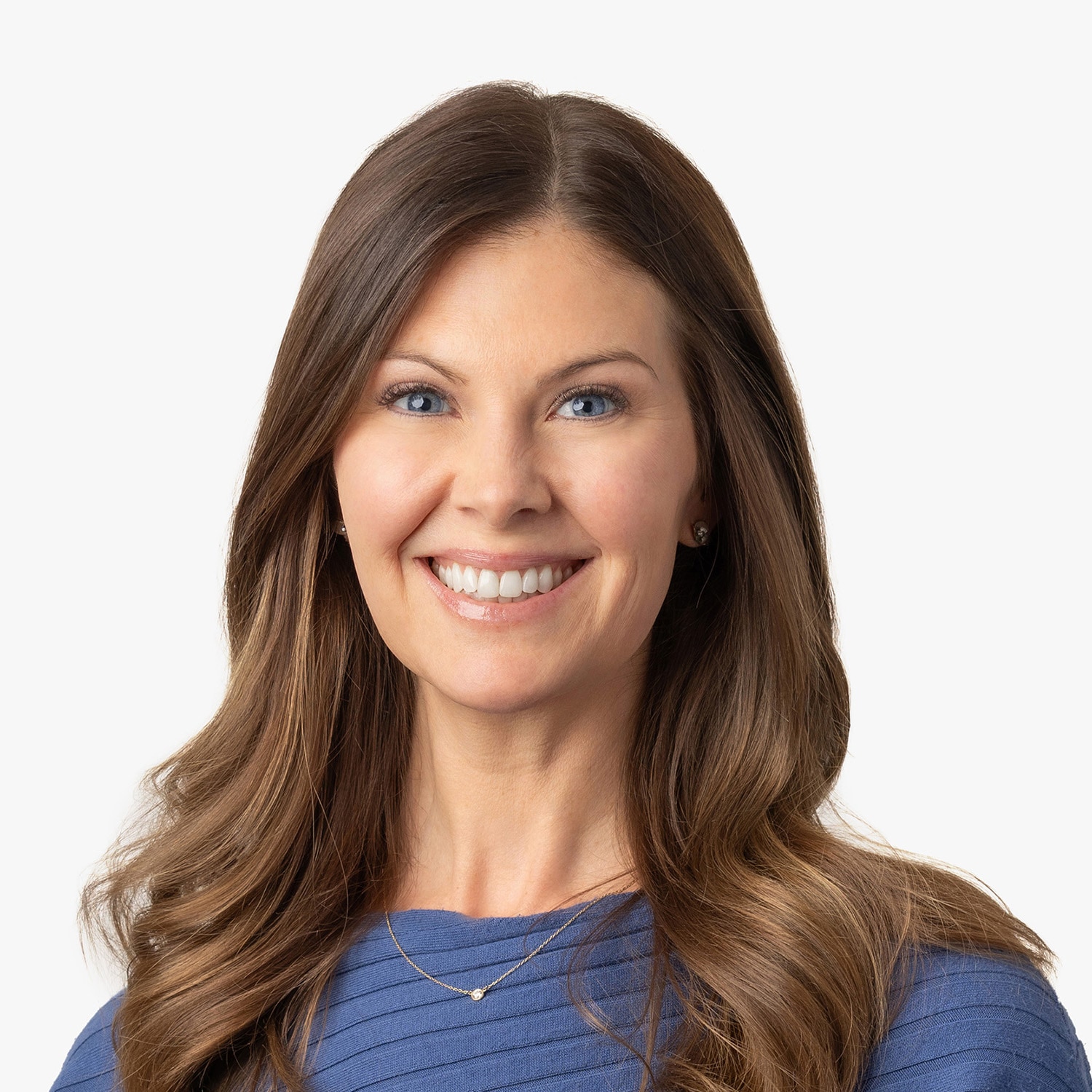Smiling woman with long brown hair wearing a blue top, looking at the camera against a white background.