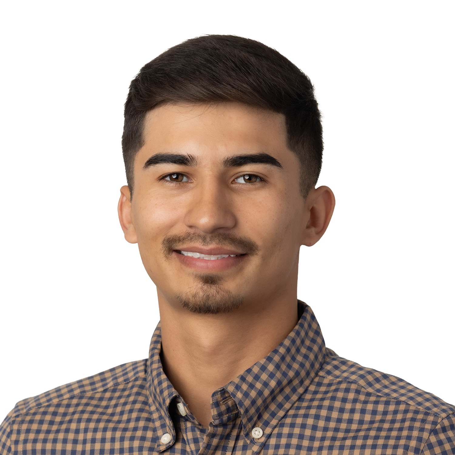 Young man with short dark hair and trimmed beard, wearing a brown checkered shirt, smiling against a white background.