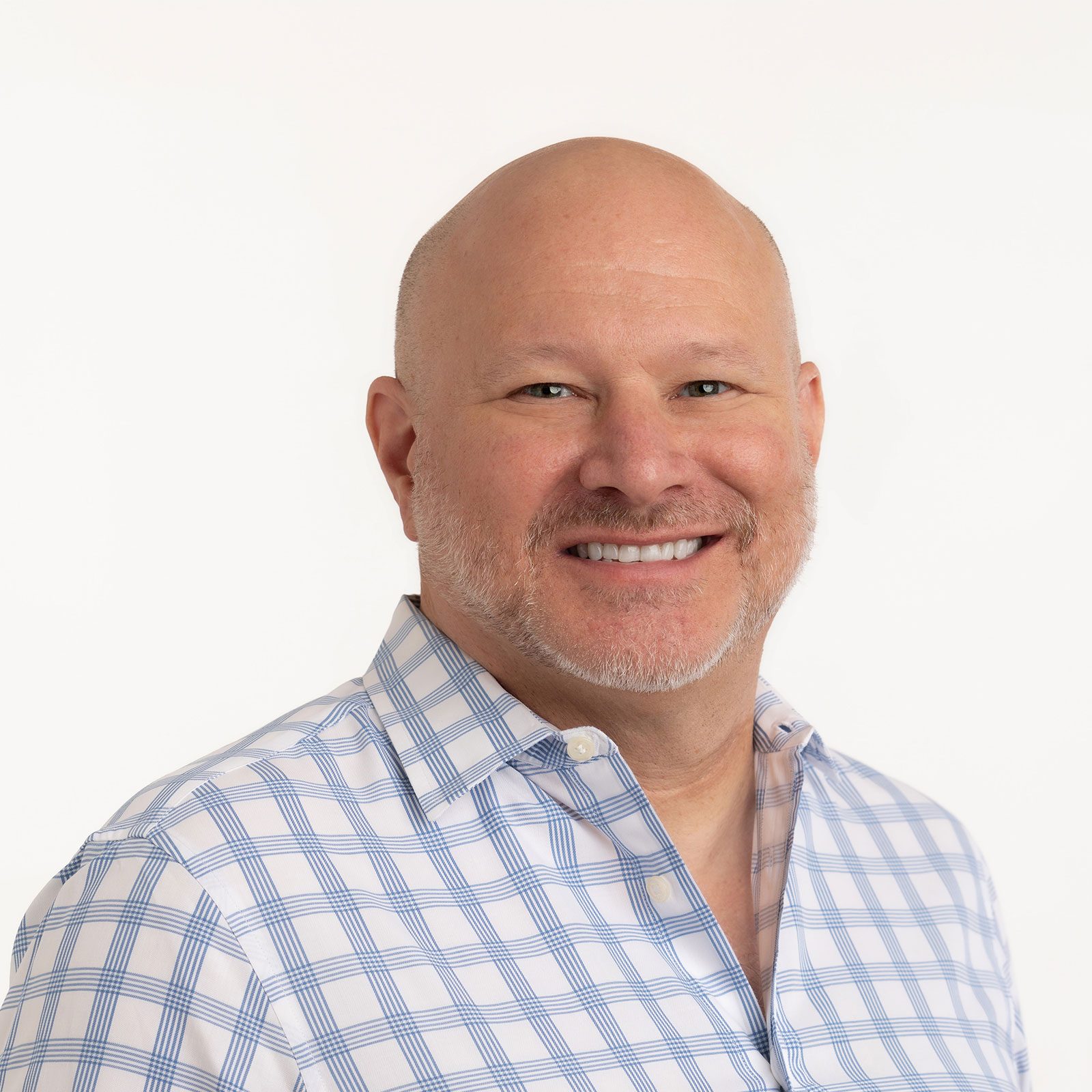 Smiling bald man with a short beard, Robert Clark, in a blue and white checkered shirt on a white background.
