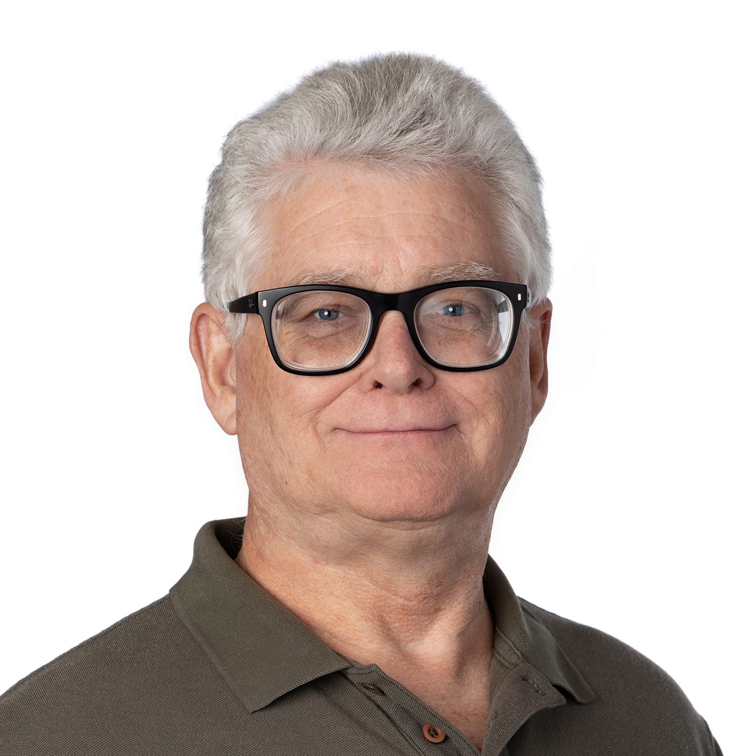 Older man with gray hair, black glasses, and a green polo shirt, smiling against a plain white background.